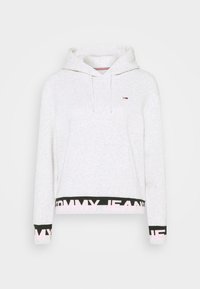 Sudadera gris clara hecha de tela suave, con un bolsillo delantero, capucha con cordón y una banda negra y rosa que dice "TOMMY JEANS" en la parte inferior.