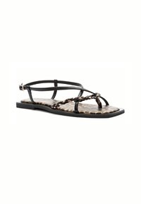 Black strappy sandal featuring a braided chain accent, a leopard print insole, and a flat sole with a secure ankle strap.
