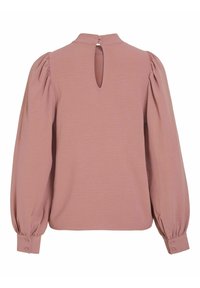 Bluza s napihnjenimi rokavi iz mehkega roza blaga s ključavnico na hrbtni strani in gumbi na zapestjih. Podrobnosti z teksturirano površino.