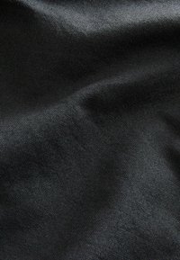 Tejido negro con una superficie texturada, que muestra un sutil patrón de tejido y un aspecto suave y drapeado.
