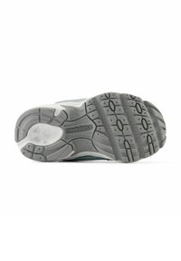 Sole di scarpa da corsa grigia con un motivo testurizzato, caratterizzata da punte in gomma per la trazione e un logo "New Balance" nella zona intermedia.