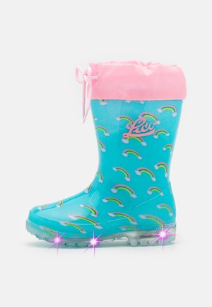 Light blue rubber rain boot with pink fabric cuff, rainbow pattern, and clear, sparkly soles. Features a drawstring and logo detail.