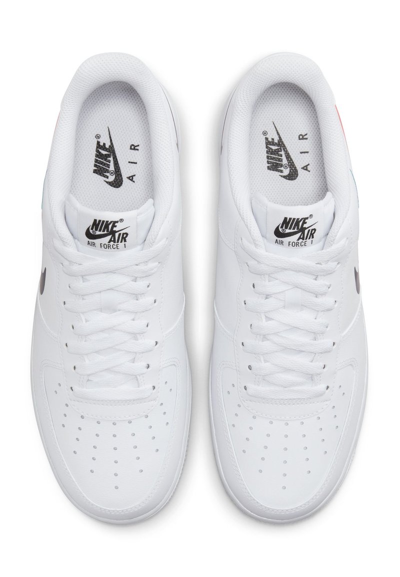 Białe sneakersy Nike Air Force 1 mają gładką skórzaną cholewkę, perforowany czubek, płaskie sznurówki oraz czarne logo na języku i boku.