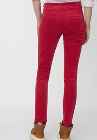 Rode corduroy broek met een slim fit, verticale ribbels en twee achterzakken. Voorzijde toont een tailleband en een strak ontwerp.