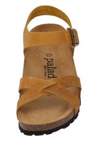 Sandalia de cuero marrón con tiras cruzadas, detalle de hebilla, plantilla acolchada y suela texturizada. Fabricada en España, talla 37.