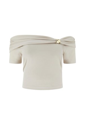Beige geribbelde top met blote schouders en korte mouwen, met een gouden accentclip aan de linkerkant van de halslijn.