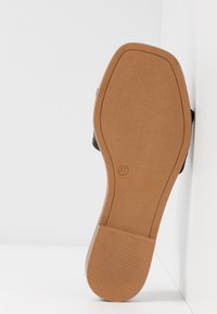 Semelle de chaussure avec grip en caoutchouc marron clair et taille 37 embossée, montrant les détails du talon et de la voûte plantaire sur fond blanc.