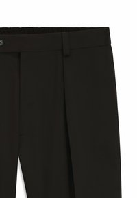Pantaloni neri con vita liscia, realizzati in tessuto testurizzato. Presentano una vita elastica e tasche laterali per la praticità.