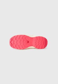 Running shoe outsole featuring a textured, multi-directional tread pattern in bright pink, with a cream-colored midsole for support.