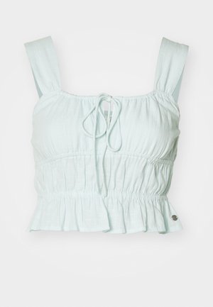 Ανοιχτό μπλε κοντό τοπ με gathered ύφασμα, ρυθμιζόμενο κόμπο μπροστά και φραμπαλά στρίφωμα. Διαθέτει φαρδιές τιράντες και μικρή μεταλλική λεπτομέρεια.