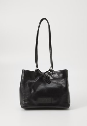 Black leather shoulder bag with long straps and a front patch displaying embossed numbers and a small ring detail.
