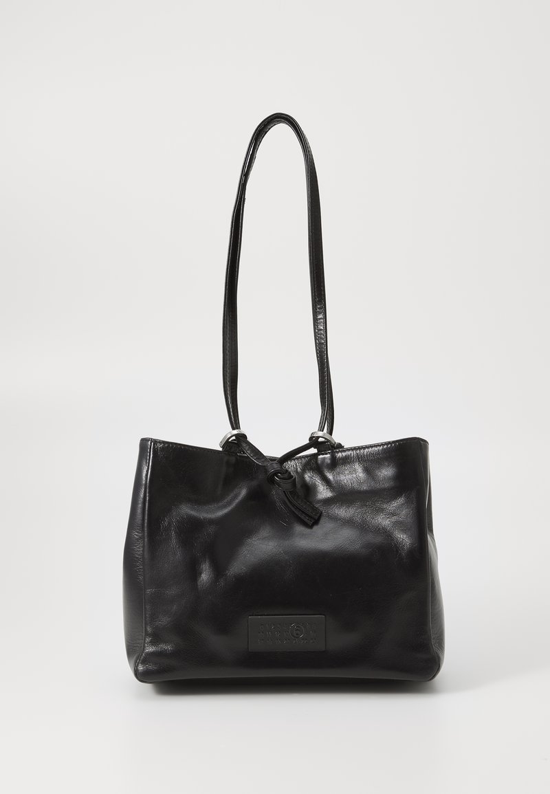 Black leather shoulder bag with long straps and a front patch displaying embossed numbers and a small ring detail.