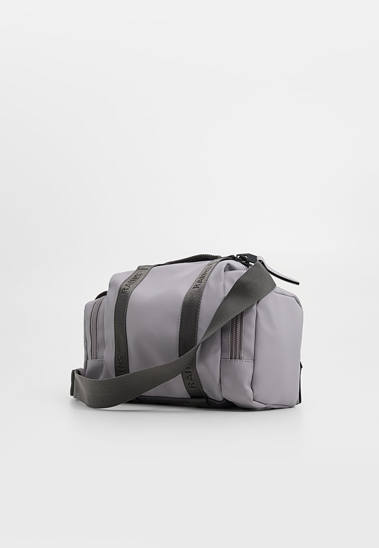 Grijze stoffen tas met een rechthoekige vorm, voorzien van donkere banden, een ritsluiting en meerdere vakken voor opberging. Gelaagd materialenafwerking.