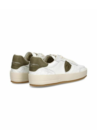 Hvide sneakers med teksturerede beige detaljer, der har en gummisål og et præget logo ved hælen. Glatte og sprukne lædermaterialer.
