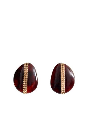 Boucles d'oreilles ovales rouge foncé avec une bande verticale dorée composée de petites pierres précieuses au centre sur fond blanc.
