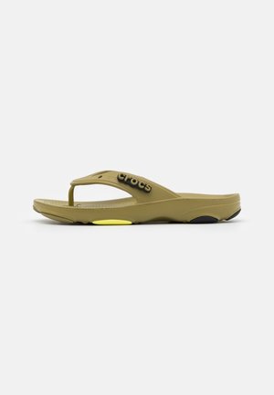Oliven grøn flip-flop sandal lavet af gummimateriale. Har et buet design, et logo på stropen og kontrasterende gul og sort accentuation.