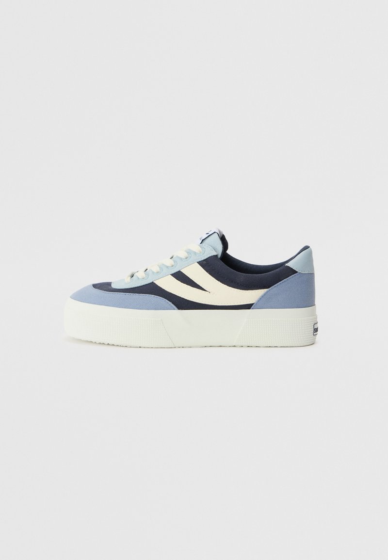 Plattform sneakers i blå, marineblå og kremfarget kanvas. Har to buede side-striper, snøring og teksturert såle for bedre grep.