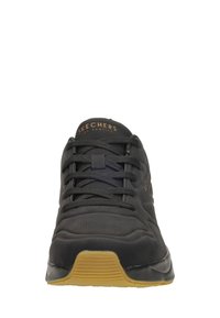 Schwarze Skechers Sneaker aus strukturiertem Stoff, mit flachen schwarzen Schnürsenkeln und einer Gummisohle. Verfügt über ein geprägtes Logo auf der Zunge und glatte Designlinien.