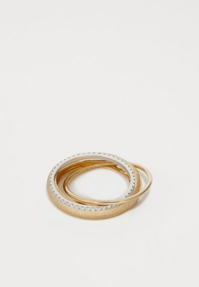 Drei ineinandergreifende Ringe aus Gold und silberfarbenem Metall. Ein Ring hat eine glatte Oberflächenbeschaffenheit, ein anderer eine strukturierte Oberfläche, und der letzte ist mit kleinen klaren Steinen besetzt.