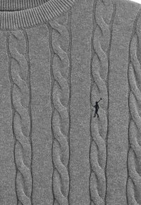 Grauer Strickpullover mit Zopfmuster, ausgestattet mit einem gerippten Ausschnitt und einem kleinen schwarzen Logo an der Seite.