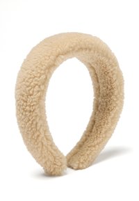 Cinta para la cabeza de felpa beige con una superficie suave y texturizada, forma redondeada y material esponjoso. Sin hardware ni acentos visibles.