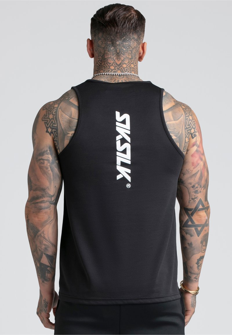 Homme musclé avec des tatouages complexes sur les bras et le cou, portant un débardeur noir avec le logo vertical blanc « SAYSKL » dans le dos.