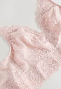 Bralette in pizzo rosa con motivi floreali, bordi ondulati e tessuto a rete testurizzato, arricchito da dettagli delicati in tutto il design.