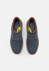 Scarpe in denim blu con accenti marroni, design con lacci, punta tonda e superficie testurizzata. Presentano suole interne imbottite e una suola flessibile.