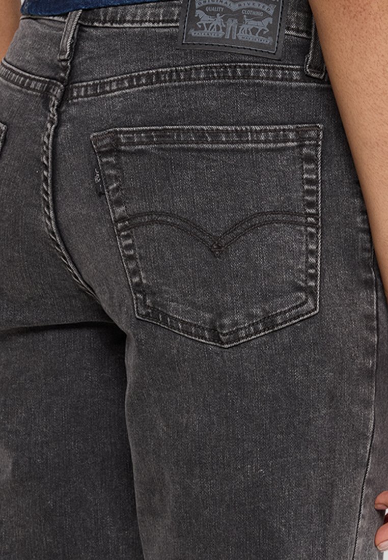 Jeans de mezclilla negra con un diseño clásico de cinco bolsillos y un distintivo detalle de bolsillo trasero curvado y cosido.