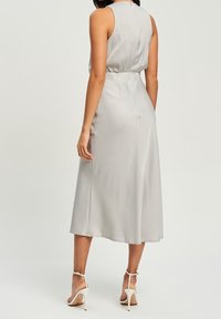 Grå satin midiklänning med en åtsittande bodice, ärmlös design och utsvängd kjol. Har en diskret bakdragkedja och slät textur.