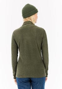Groene geribbelde lange mouw top met een hoge kraag, gemaakt van zachte stof, gecombineerd met een bijpassende groene geribbelde beanie.