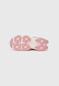 Semelle de chaussure avec une base en caoutchouc rose, des accents en forme de diamant jaune, et des motifs texturés pour l'adhérence. Forme arrondie avec des segments distincts.