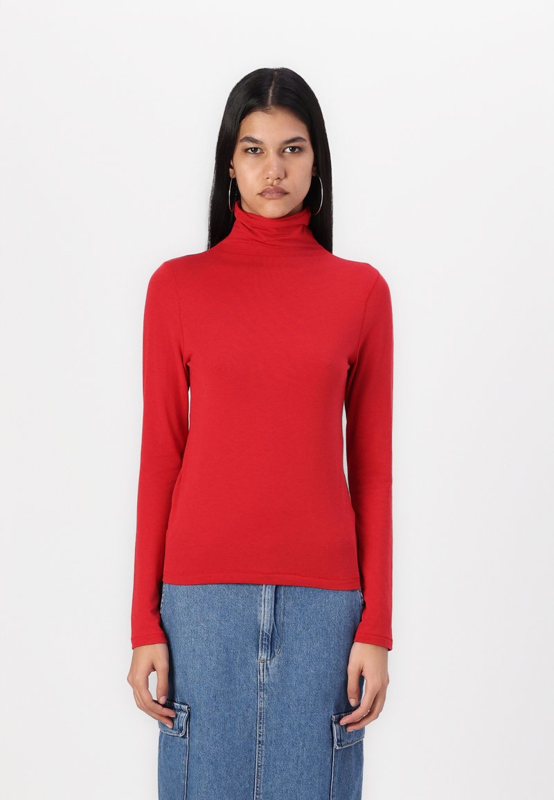 Rød langermet høyhalset topp laget av glatt stoff, tettsittende design, med høy krage og ren kant. Kombinert med et denimskjørt.