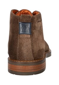 Bruine suède enkellaarzen met een gladde textuur, een leren voering en een donkerblauw logodetail aan de achterkant. Heeft een houten zool.