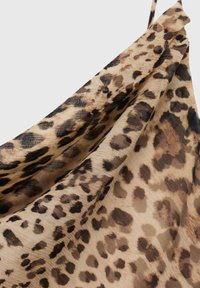 Nastro in tessuto con stampa leopardata che presenta un mix di macchie marroni, beige e nere su uno sfondo beige, con una consistenza morbida e fluente.