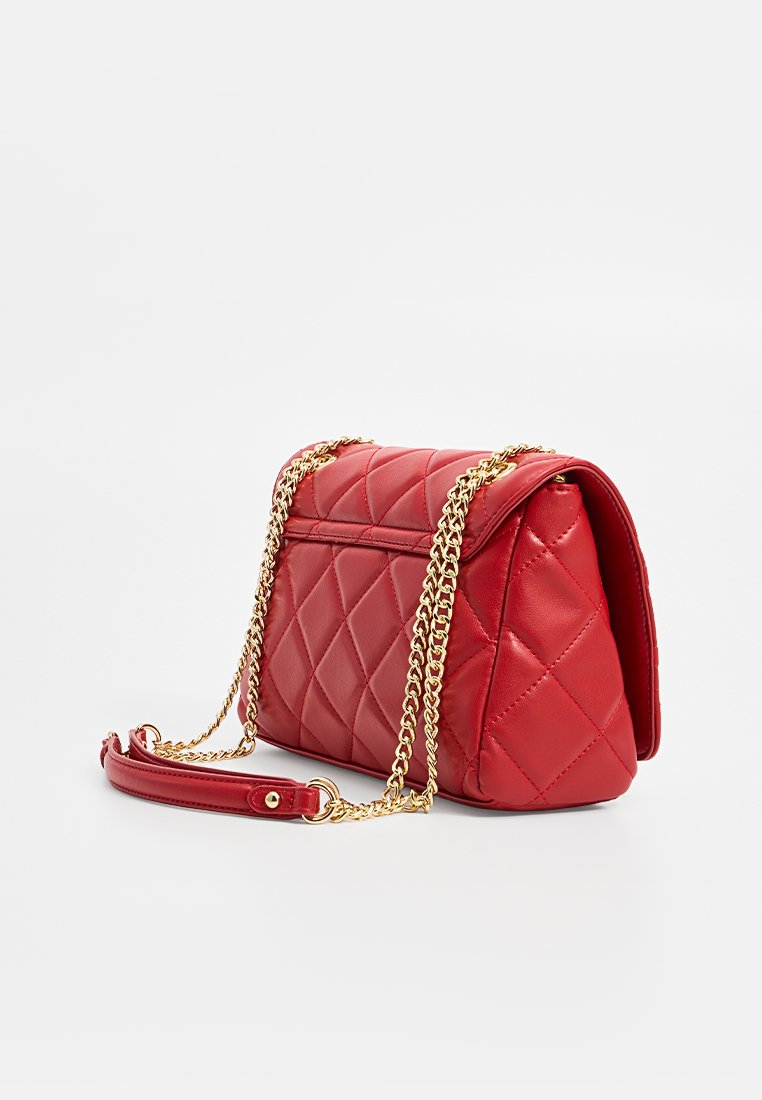 Rote gesteppte Lederhandtasche mit goldener Kettenriemen, rechteckiger Form und Klappverschluss, auf einem weißen Hintergrund präsentiert.