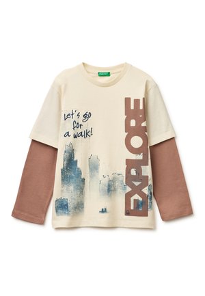 Kremowy, długorękawowy, warstwowy T-shirt z brązowymi rękawami, nadrukiem panoramy miasta, napisem „Chodźmy na spacer!” oraz dużym pionowym napisem „EXPLORE”.