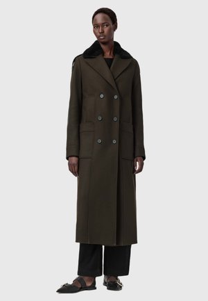 Lang olijfgroen jasje met een dubbelgeknopte ontwerp, grote zakken en een zwarte nepleren kraag. Gladde textuur, op maat gemaakte silhouet.