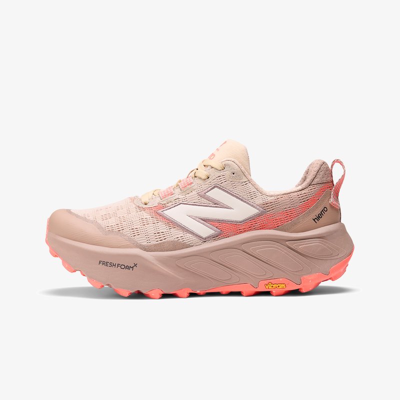 Bežīgas un korallkrāsas skriešanas apavi ar sietu augšdaļu, Fresh Foam vidusdaļu un Vibram zoli. Iezīmē īpašu tekstūras dizainu un izteiktu logotipu.