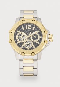 Silberne und goldene Edelstahl-Uhr mit schwarzem Zifferblatt, Chronographenfunktionen, strukturiertem schwarzen Zifferblatt, großer Ziffer 12 und goldenen Akzenten.