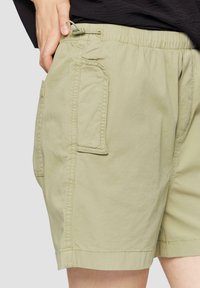 Lichtgroene shorts met een elastische tailleband en verstelbaar trekkoord. Voorzien van twee zijzakken en gestikte details. Casual ontwerp.