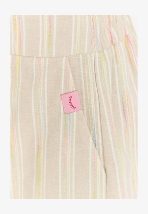 Beżowy materiał z pionowymi pastelowymi paskami oraz wszytą różową metką z zamkniętym wzorem rzęs w pobliżu szwu kieszeni.