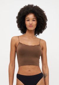 Camisola corta marrone realizzata in tessuto morbido. Presenta spalline sottili regolabili e un delicato bordo in pizzo lungo il scollo.