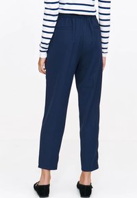 Granatowe lekkie spodnie z elastycznym pasem, luźny krój, kieszenie boczne i skrócona długość do kostek.