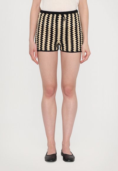 Shorts intrecciati neri e crema con un motivo geometrico, dotati di vita con coulisse e finitura testurizzata.
