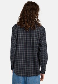 Button-up skjorte i marinblå plaid med ternet mønster i grøn og pink. Lange ærmer med knapskud, afslappet pasform, materiale i bomuld.
