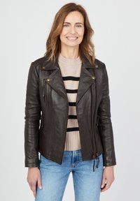 Ruskea nahkainen moottoripyöräntakki, jossa on vetoketjulliset taskut ja napit, päällä vaaleansävyinen raidallinen neule ja siniset farkut. Sujuva pinta.