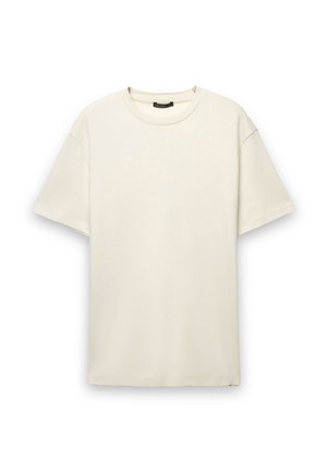 T-shirt di cotone color crema con vestibilità comoda, maniche corte e scollatura rotonda. Tessuto liscio senza motivi o dettagli visibili.