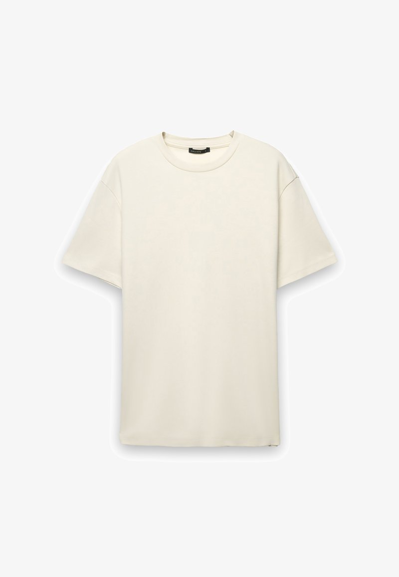 T-shirt di cotone color crema con vestibilità comoda, maniche corte e scollatura rotonda. Tessuto liscio senza motivi o dettagli visibili.