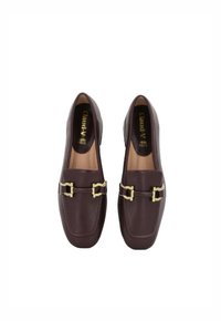 Mocassini in pelle bordeaux con una texture liscia, caratterizzati da due dettagli in metallo dorato nella parte anteriore e da una silhouette classica.